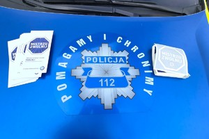 Na zdjęciu widzimy policjanta oraz kierującego z ulotkami oraz naklejką Mistrzu Zwolnij