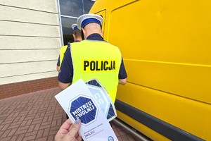 Na zdjęciu widzimy policjanta oraz kierującego z ulotkami oraz naklejką Mistrzu Zwolnij