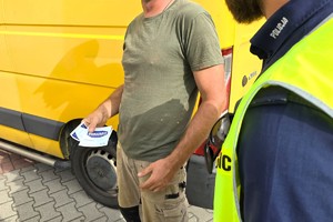Na zdjęciu widzimy policjanta oraz kierującego z ulotkami oraz naklejką Mistrzu Zwolnij