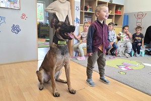 Na zdjęciu widzimy psa służbowego oraz dzieci