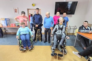 Na zdjęciu widzimy policjanta, psa służbowego oraz podopiecznych