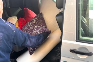 Na zdjęciu widzimy policjanta przekazującego najpotrzebniejsze rzeczy osobą w kryzysie bezdomności