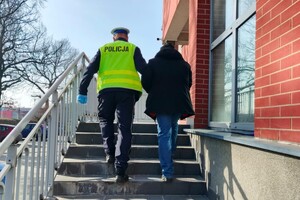 Na zdjęciu widzimy policjanta i zatrzymanego mężczyznę