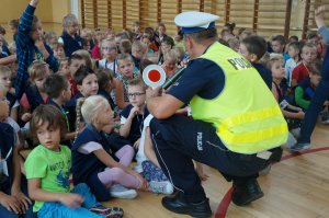 Policjant pokazuje dzieciom policyjny &quot;lizak&quot;