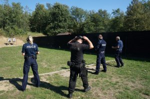 Policjanci przygotowują się do oddania strzałów do tarczy