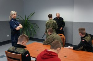 Policjanci omawiają uczniom zasady posługiwania się broniom