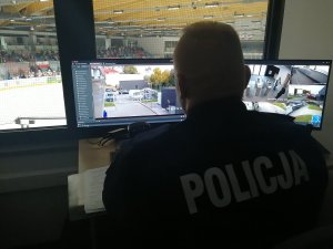 policjant przeglądający monitoring podczas meczu hokeja na lodzie