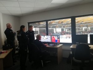 policjanci w pomieszczeniu monitoringu lodowiska