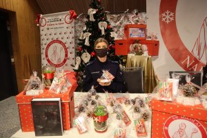 Policjantka prezentuje zapakowany upominek świąteczny
