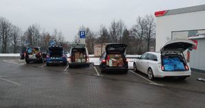 Pojazdy na parkingu z otwartymi zapakowanymi paczkami bagażnikami
