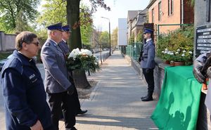 Kierownictwo bytomskiej Policji i kapelan z kwiatami pod pomnikiem zabitego policjanta