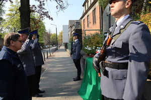 Komendanci oddają cześć zabitemu policjantowi salutują przed pomnikiem