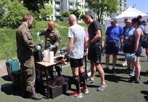 Żołnierze nalewają zupę uczestnikom zawodów