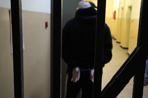 Zatrzymany mężczyzna doprowadzony do pomieszczenia dla zatrzymanych.
