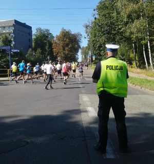 Zdjęcie przedstawia policjanta, który zabezpiecza Półmaraton.