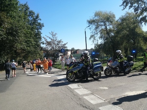 Zdjęcie przedstawia policjantów na motocyklach, którzy zabezpieczają trasę biegu.