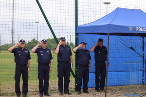 Na zdjęciu pięciu salutujących oficerów w mundurach policyjnych, na głowach czapki