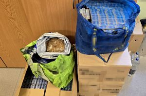 na zdjęciu kartonowe pudełka z papierosami, na nich worki z papierosami i krajanką tytoniu