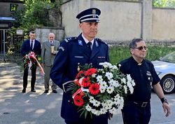 na zdjęciu Pierwszy Zastępca Komendanta Miejskiego Policji w Bytomiu młodszy inspektor Michał Sokołowski wraz z kapelanem księdzem Joachimem Gondro trzymający kwiaty., za nimi ojciec poległego policjanta oraz Prezydenta Miasta Bytomia Mariusz Wołosz