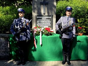 na zdjęciu warta honorowa, dwaj policjanci stojący przy pomniku.