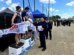 na zdjęciu naczelnik wręczający nagrody osobom stojącym na podium