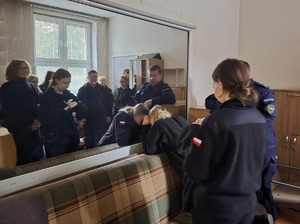 na zdjęciu licealiści i policjant przy lustrze weneckim, jedna uczennica przy lustrze zagląda w głąb