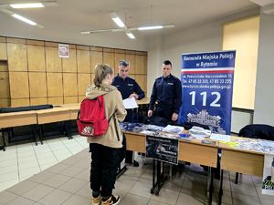 na zdjęciu dwóch policjantów przy stoisku obok nich uczennica