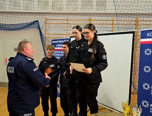 na zdjęciu bytomski komendant wręczający puchar i dyplom drużynie na trzecim miejscu podium