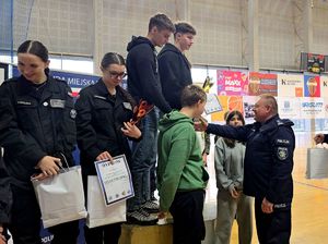 na zdjęciu bytomski komendant wręczający puchar i dyplom drużynie na pierwszym miejscu podium