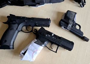 na zdjęciu trzy sztuki broni krótkiej leżące na biurku