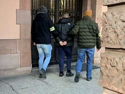 na zdjęciu przed budynkiem sądu, dwóch nieumundurowanych policjantów prowadzących zatrzymanego w kajdankach