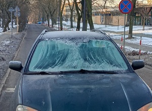 na zdjęciu na przejściu dla pieszych przód pojazdu osobowego, szyby pojazdu pokryte szronem