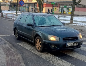 na zdjęciu na przejściu dla pieszych pojazd osobowy, szyby pojazdu pokryte szronem