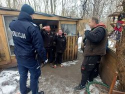 na zdjęciu policjant przy altanie, przy nim trzy osoby