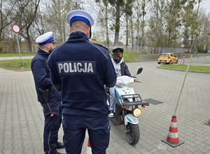 widzimy dwóch policjantów drogówki, przed nimi uczestnik turnieju na motorowerze