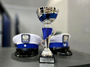 puchar, za nim dwie czapki policjantów ruchu drogowego