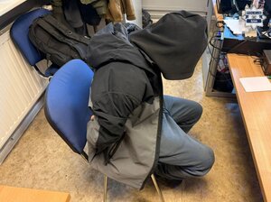 zatrzymany siedzący na krześle, ma dłonie w kajdankach zapiętych z tyłu