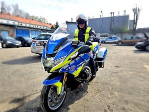 policjant siedzący na motocyklu służbowym