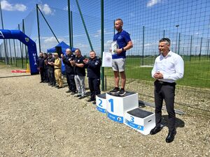 biegacz stojący na podium obok bytomski komendant i mundurowi z drugiej strony prezydent miasta Bytomia