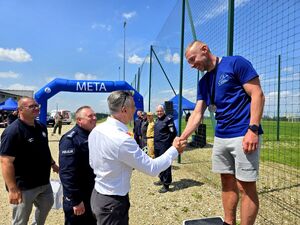 wręczanie nagród przez komendanta i prezydenta miasta Bytomia biegaczowi stojącemu na podium