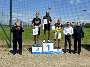 trzech biegaczy stojących na podium obok bytomski komendant z drugiej strony prezydent miasta Bytomia i kolejny mundurowy
