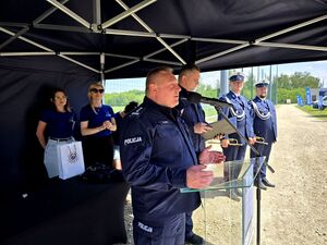 bytomski komendant stojący pod namiotem i przemawiający przed mikrofonem, obok niego mundurowi