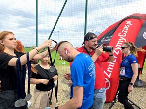 dziewczyny zakładają medal uczestnikowi biegu