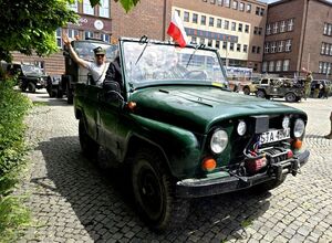 pojazd zielonego koloru w nim kilka osób