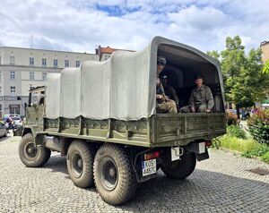 pojazd militarny w nim kilku mężczyzn w mundurach