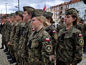 młodzi ludzie w strojach moro stoją w dwóch rzędach