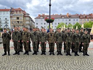 uczniowie klas mundurowych w strojach moro ustawieni w dwóch rzędach na placu