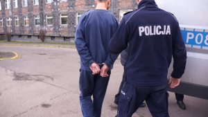 Policjant prowadzi zatrzymanego