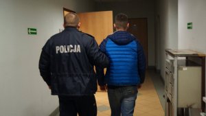 Policjant prowadzi zatrzymanego