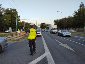Zdjęcie przedstawia policjanta kierującego ruchem